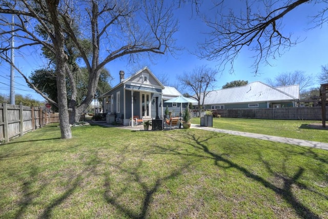 back of property featuring a chimney, a patio area, and metal roof