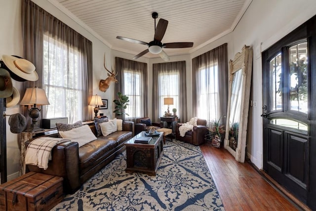 living area featuring wood-type flooring, ceiling fan, and crown molding