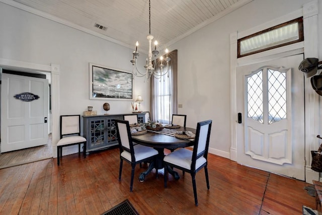 dining area with a chandelier, crown molding, hardwood / wood-style flooring, healthy amount of natural light, and baseboards
