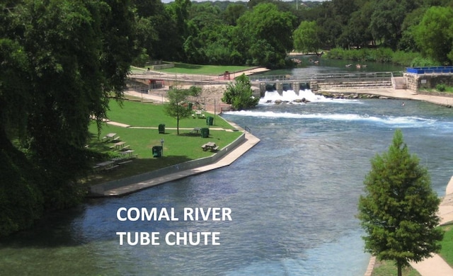 surrounding community with a wooded view and a water view