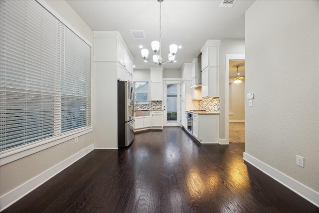 7508 Pantherpaw St, Austin, TX 78757 - kitchen featuring stainless steel appliances, decorative backsplash, a chandelier, light countertops, and white cabinets
