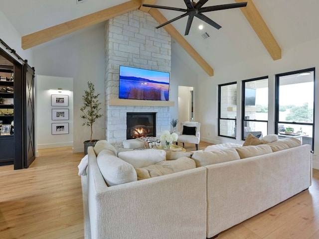 871 Blackbuck Ridge Dr, Lampasas, TX 76550 - living room featuring visible vents, light wood-style flooring, a stone fireplace, and a ceiling fan