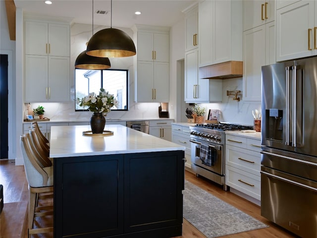 871 Blackbuck Ridge Dr, Lampasas, TX 76550 - kitchen featuring a kitchen bar, high quality appliances, a kitchen island, wood finished floors, and decorative backsplash