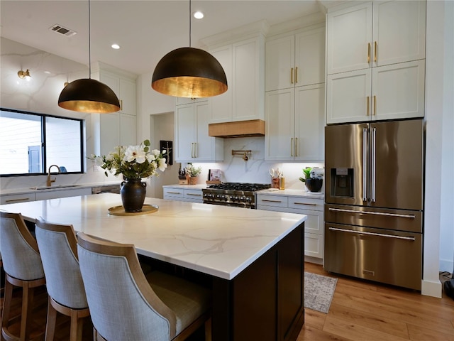 871 Blackbuck Ridge Dr, Lampasas, TX 76550 - kitchen featuring visible vents, a sink, a kitchen island, stove, and high end refrigerator