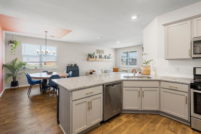 321 Cherry Laurel Ln, Kyle, TX 78640 - kitchen featuring gray cabinets, a sink, a peninsula, an inviting chandelier, and stainless steel appliances