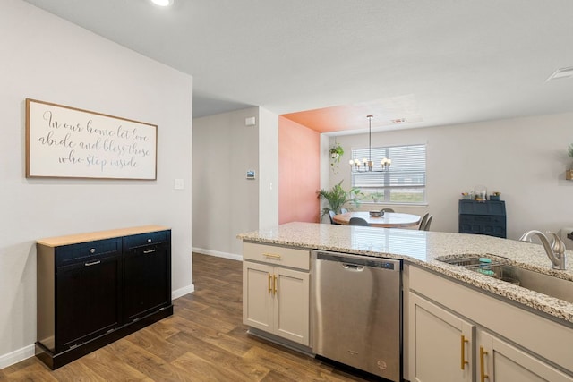 321 Cherry Laurel Ln, Kyle, TX 78640 - kitchen with light stone countertops, an inviting chandelier, a sink, dishwasher, and wood finished floors