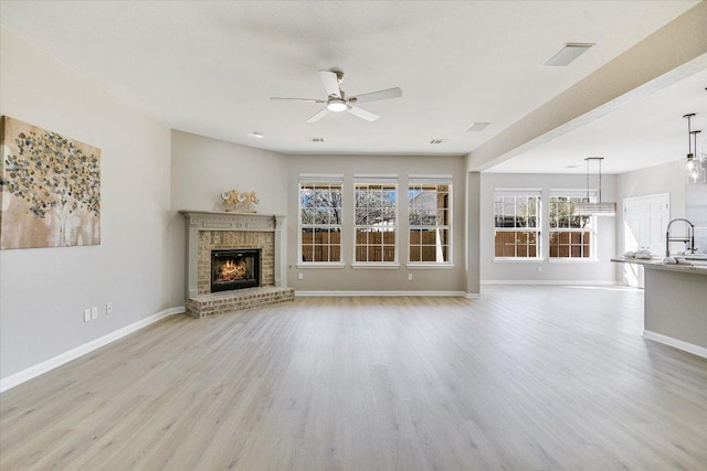 9201 Cessna Ln, Austin, TX 78717 - unfurnished living room featuring a ceiling fan, wood finished floors, baseboards, a brick fireplace, and a sink