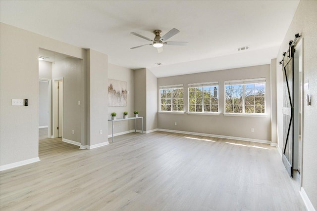 9201 Cessna Ln, Austin, TX 78717 - unfurnished living room with a barn door, light wood-style flooring, ceiling fan, and baseboards