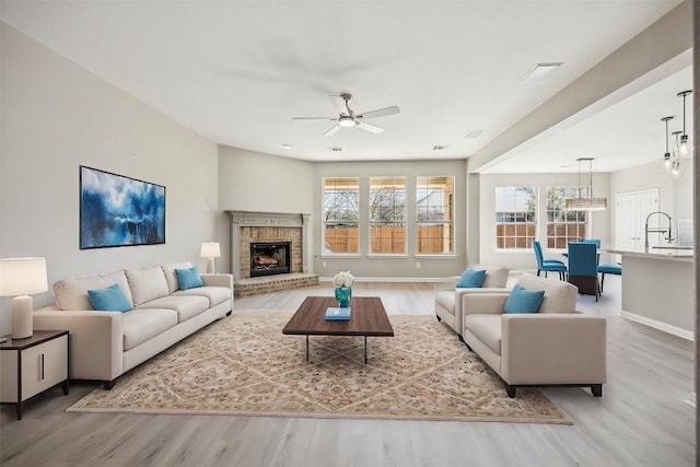 9201 Cessna Ln, Austin, TX 78717 - living room with wood finished floors, ceiling fan, baseboards, and a brick fireplace