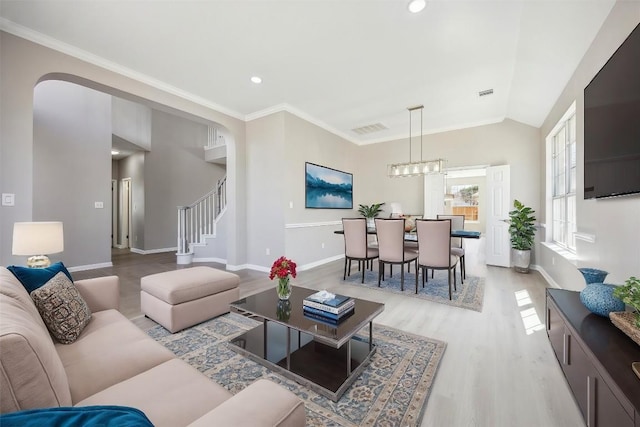 9201 Cessna Ln, Austin, TX 78717 - living room featuring light wood-style floors, baseboards, stairs, ornamental molding, and arched walkways