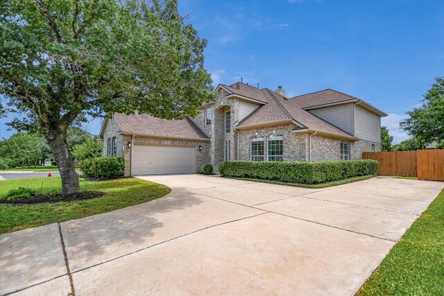 9201 Cessna Ln, Austin, TX 78717 - view of front facade featuring concrete driveway, brick siding, a garage, a chimney, and a shingled roof