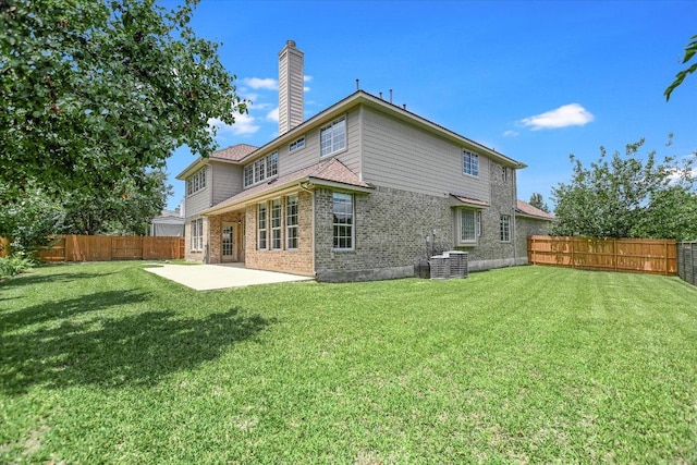 9201 Cessna Ln, Austin, TX 78717 - rear view of house featuring a patio, brick siding, a chimney, and central AC unit