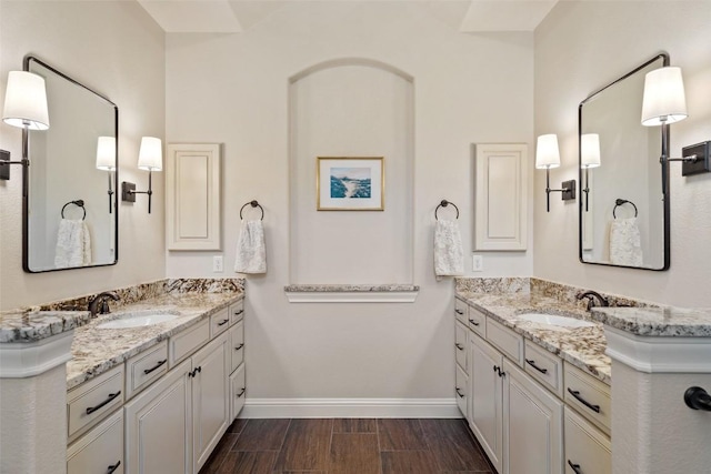 9525 Stratus Dr, Dripping Springs, TX 78620 - full bath with baseboards, two vanities, and wood finish floors