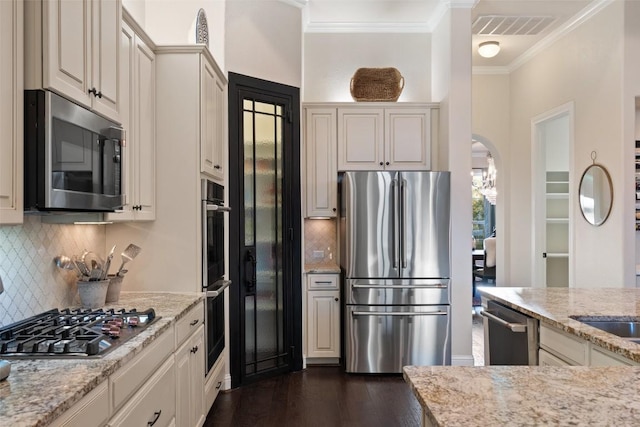 9525 Stratus Dr, Dripping Springs, TX 78620 - kitchen featuring stainless steel appliances, ornamental molding, dark wood-style floors, light stone countertops, and backsplash