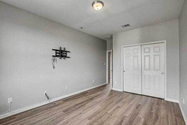 512 Eberhart Ln Unit 1207, Austin, TX 78745 - unfurnished bedroom with wood finished floors, a closet, and baseboards
