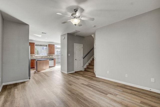 512 Eberhart Ln Unit 1207, Austin, TX 78745 - unfurnished living room featuring light wood-style flooring, ceiling fan, and baseboards