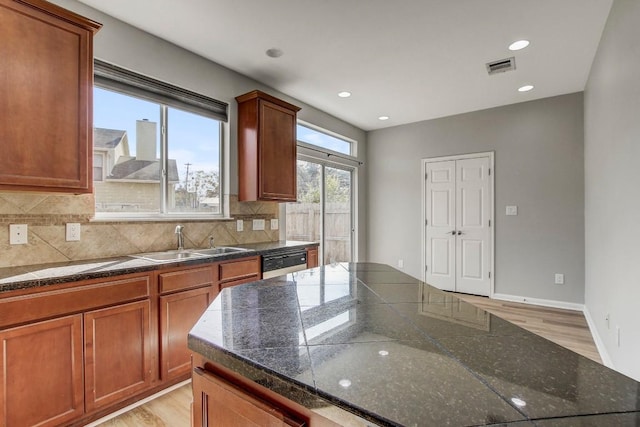 512 Eberhart Ln Unit 1207, Austin, TX 78745 - kitchen featuring a sink, light wood finished floors, tasteful backsplash, dark countertops, and recessed lighting