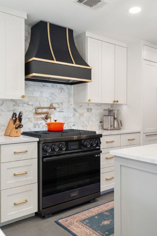 3506 Clearview Dr, Austin, TX 78703 - kitchen featuring black / electric stove, premium range hood, white cabinets, decorative backsplash, and tile patterned floors