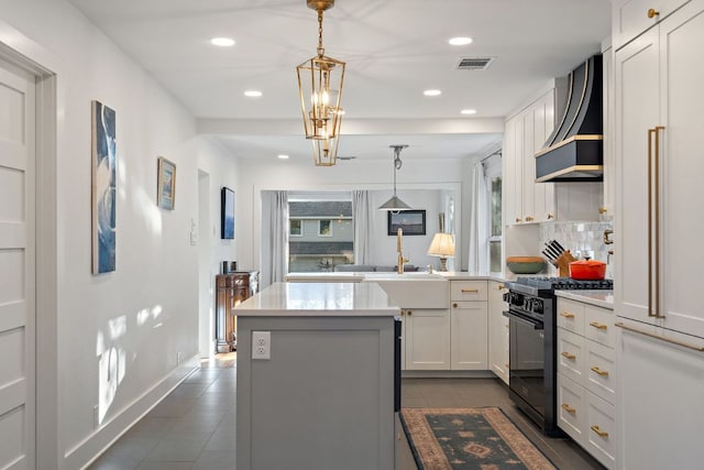 3506 Clearview Dr, Austin, TX 78703 - kitchen featuring black gas range, wall chimney exhaust hood, dark tile patterned flooring, light countertops, and recessed lighting