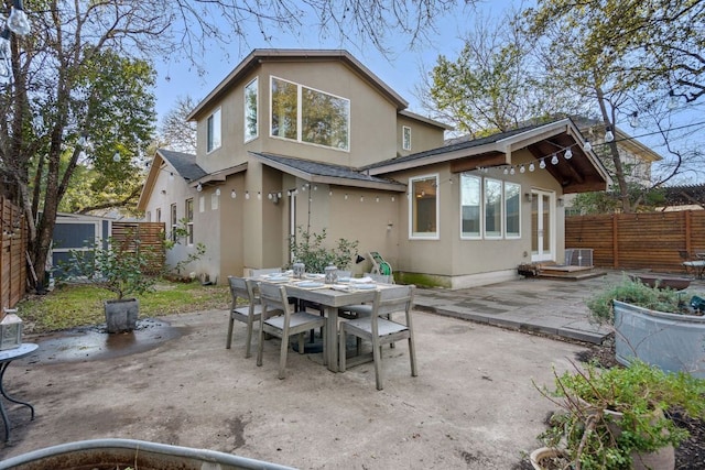 3506 Clearview Dr, Austin, TX 78703 - back of property featuring stucco siding, a patio, outdoor dining space, a fenced backyard, and roof with shingles
