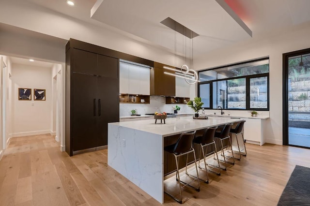 106 Bella Montagna Cir, Austin, TX 78734 - kitchen featuring modern cabinets, a kitchen island, light wood-type flooring, hanging light fixtures, and recessed lighting