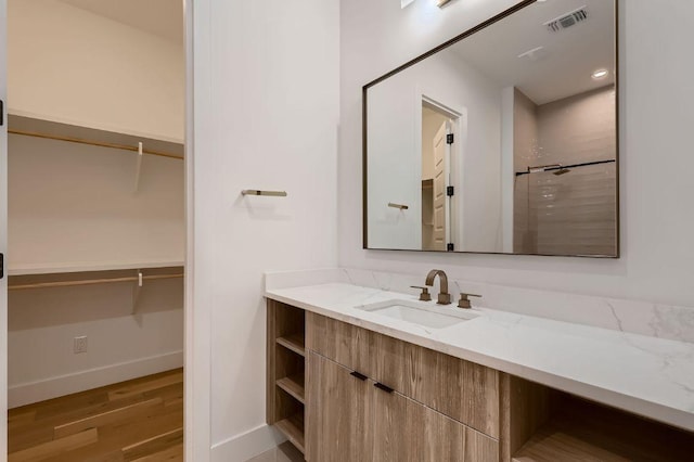 106 Bella Montagna Cir, Austin, TX 78734 - bathroom with vanity, wood finished floors, a shower, and a spacious closet