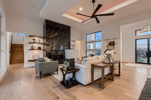 106 Bella Montagna Cir, Austin, TX 78734 - living room with light wood finished floors, stairs, a tray ceiling, and ceiling fan