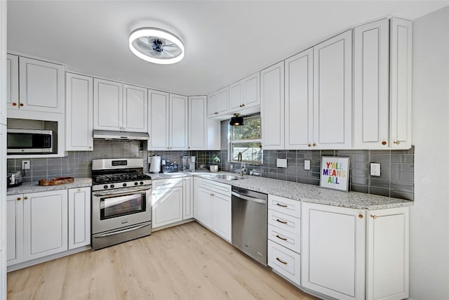 1205 Westmoor Dr, Austin, TX 78723 - kitchen with appliances with stainless steel finishes, a sink, under cabinet range hood, and decorative backsplash