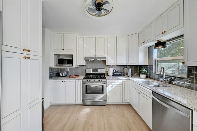 1205 Westmoor Dr, Austin, TX 78723 - kitchen with stainless steel appliances, a sink, backsplash, and light wood-style flooring