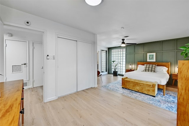 1205 Westmoor Dr, Austin, TX 78723 - bedroom with wood finished floors, a closet, a decorative wall, and a ceiling fan