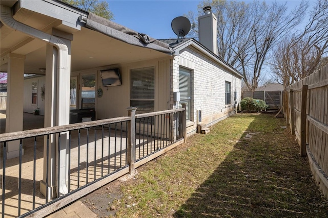 2103 Heather Dr, Cedar Park, TX 78613 - view of side of home with a fenced backyard, a patio area, a chimney, and brick siding