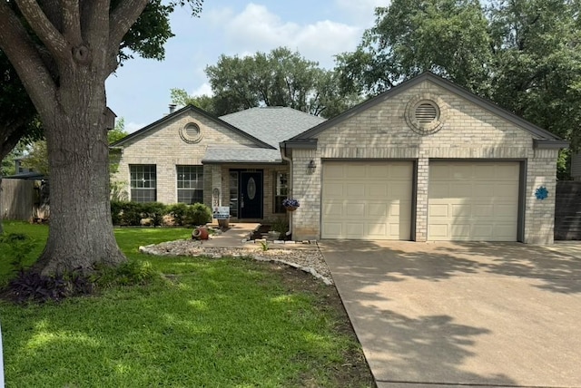 2103 Heather Dr, Cedar Park, TX 78613 - view of front of home featuring an attached garage, concrete driveway, a front lawn, and brick siding