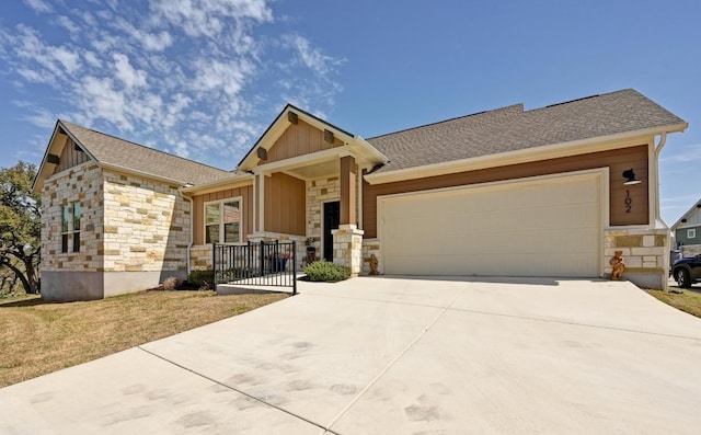view of front of property featuring board and batten siding, an attached garage, driveway, and stone siding