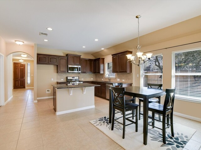 2829 Homecoming, Leander, TX 78641 - kitchen featuring stainless steel appliances, arched walkways, a chandelier, tasteful backsplash, and a kitchen island