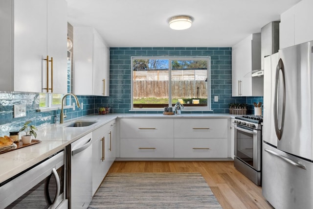 5307 Halmark Dr, Austin, TX 78723 - kitchen with stainless steel appliances, light wood-style floors, wall chimney exhaust hood, and plenty of natural light