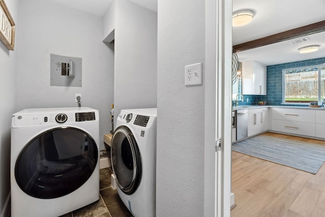 5307 Halmark Dr, Austin, TX 78723 - laundry area featuring independent washer and dryer, electric panel, and light wood finished floors