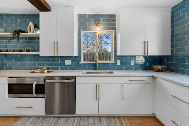 5307 Halmark Dr, Austin, TX 78723 - kitchen with stainless steel appliances, tasteful backsplash, white cabinets, light stone counters, and light wood finished floors