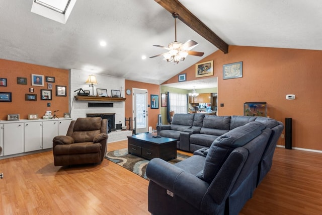 1304 Gatlinburg Dr, Pflugerville, TX 78660 - living area featuring a fireplace, lofted ceiling with skylight, light wood-style flooring, and ceiling fan with notable chandelier