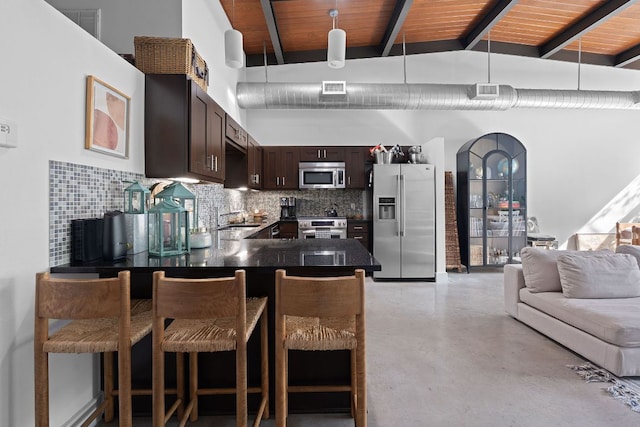 kitchen with finished concrete floors, visible vents, beam ceiling, dark brown cabinets, and stainless steel appliances