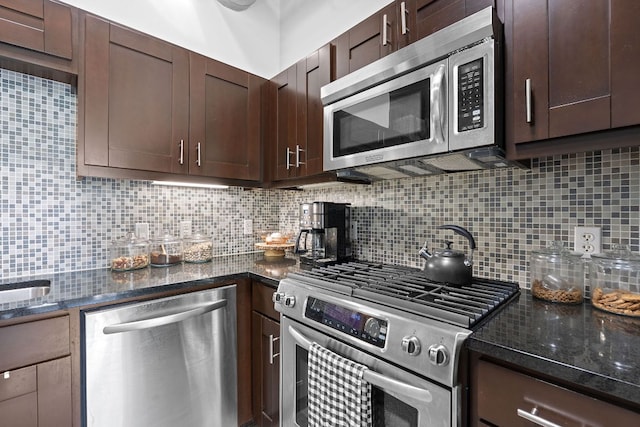 kitchen with appliances with stainless steel finishes, decorative backsplash, dark brown cabinetry, and dark stone countertops