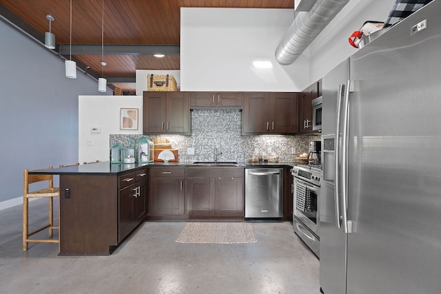 kitchen with decorative backsplash, dark countertops, concrete flooring, a peninsula, and stainless steel appliances