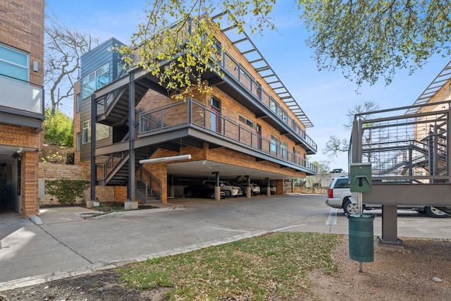 view of building exterior with covered parking and stairway