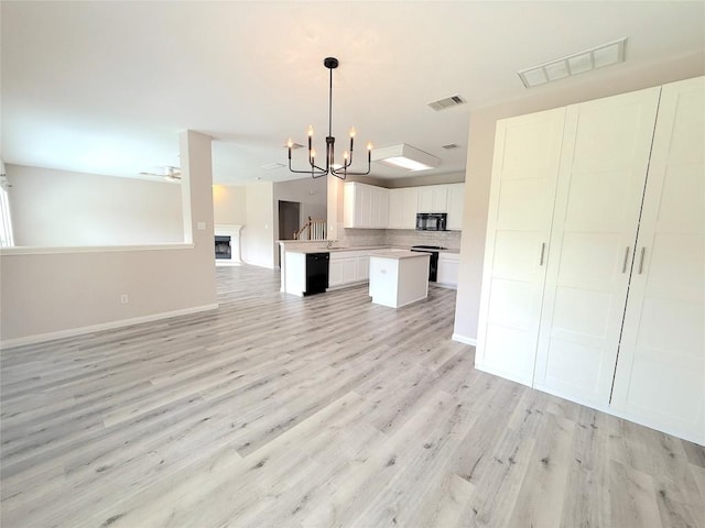 10933 Casitas Dr, Austin, TX 78717 - kitchen featuring open floor plan, black appliances, a chandelier, light wood-type flooring, and light countertops