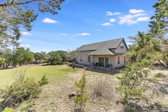 14415 Echo Blf, Austin, TX 78737 - back of house featuring a patio, a lawn, stucco siding, and a shingled roof