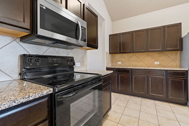 5825 Roderick Dr, Austin, TX 78724 - kitchen with black / electric stove, stainless steel microwave, dark brown cabinetry, decorative backsplash, and light tile patterned floors