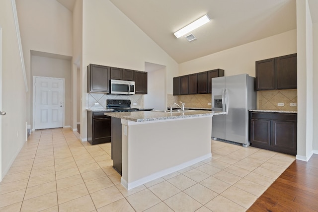 5825 Roderick Dr, Austin, TX 78724 - kitchen with appliances with stainless steel finishes, dark brown cabinets, high vaulted ceiling, backsplash, and a sink