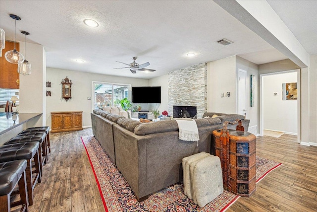 2402 Stevens Cv, Austin, TX 78723 - living room with a ceiling fan, hardwood / wood-style flooring, baseboards, a textured ceiling, and recessed lighting