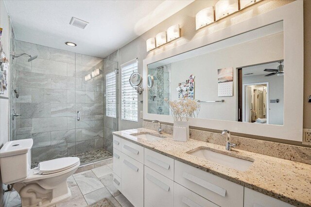 2402 Stevens Cv, Austin, TX 78723 - full bath featuring a stall shower, double vanity, a ceiling fan, and marble look tile flooring
