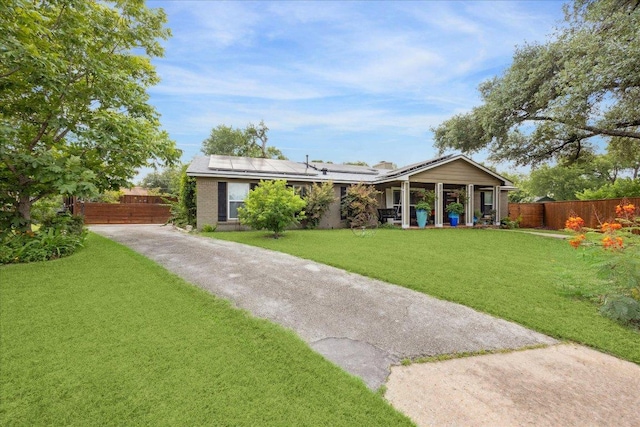 2402 Stevens Cv, Austin, TX 78723 - rear view of house featuring solar panels, a porch, concrete driveway, brick siding, and a chimney
