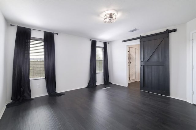 12024 Roving Pass, Elgin, TX 78621 - empty room with dark wood-style floors, a barn door, and baseboards